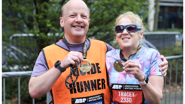 Picture of Dafydd wearing a Guide Runner top with a VI runner both holding medals.